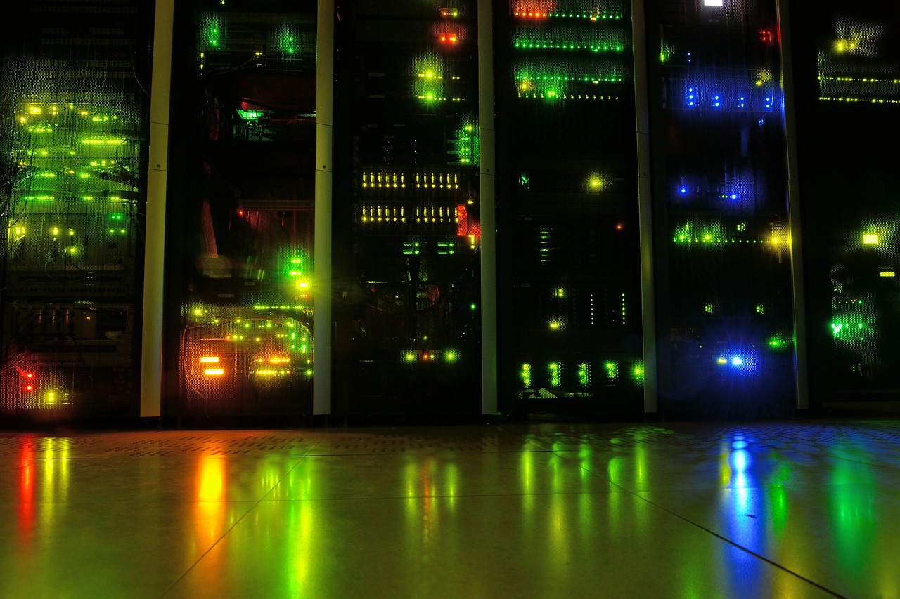 Server racks with network lights inside a dark data center.